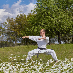 Two blows hands the sportsman beats on a background of greens Kaderov