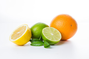 Fototapeta na wymiar Composition of lemon orange and lime and mint leaves