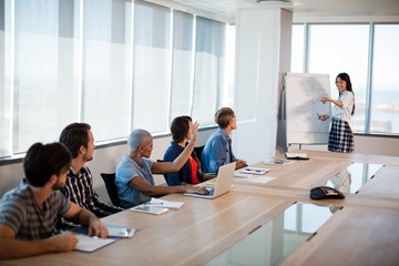 Woman giving presentation to her colleagues in conference room