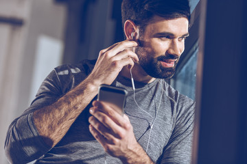 portrait of man listening music in earphones and look out window