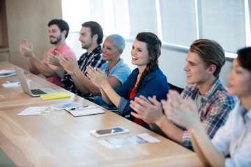 Creative business team applauding in meeting room