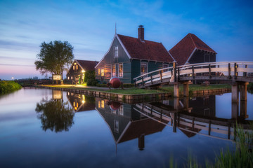 Fototapeta na wymiar Typical Dutch farm reflected in the canal, Zaanse Schans near Amsterdam
