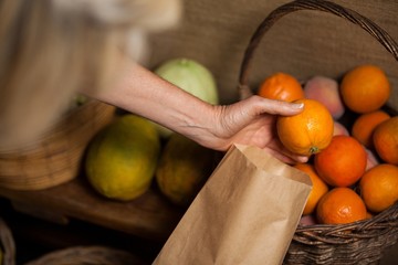 Staff packing oranges in paper bag