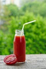 Tomato  juice in glass bottles with straws.