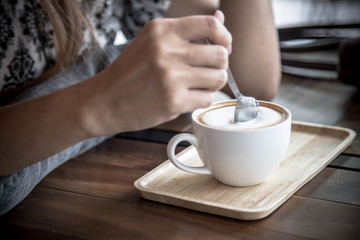 cup of hot coffee with woman and spoon