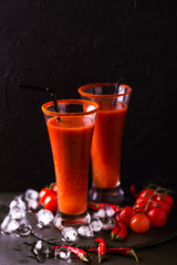 Bloody Mary cocktail with chili pepper, ice and celery.