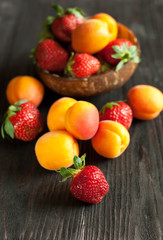 apricots and strawberry on a wooden table