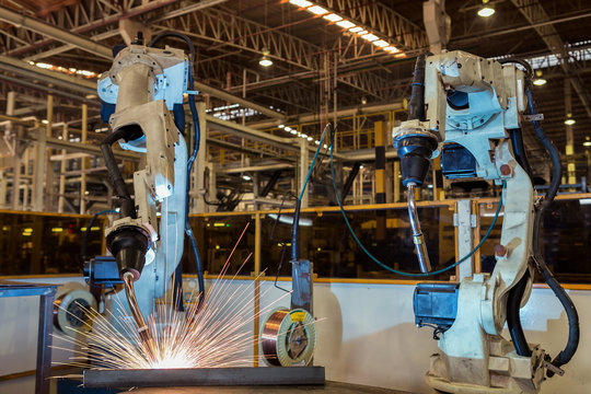 Team robots are welding assembly part in car factory