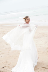 Fototapeta na wymiar Bride walking on a sandy beach