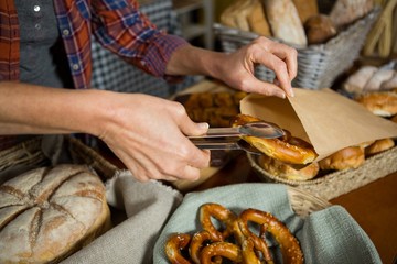 staff packing pretzel bread in paper bag