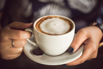 woman hands holding a cup of coffee