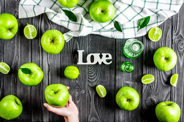 Fototapeta na wymiar Summer food - green apples and word love on dark background top view