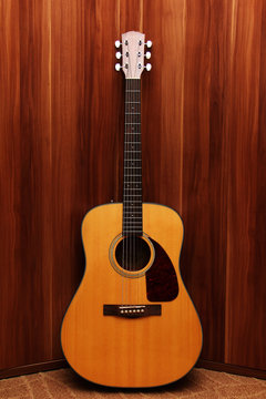 Acoustic classical guitar on a wooden background.