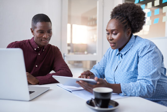 Young African businesspeople using technology together in an office