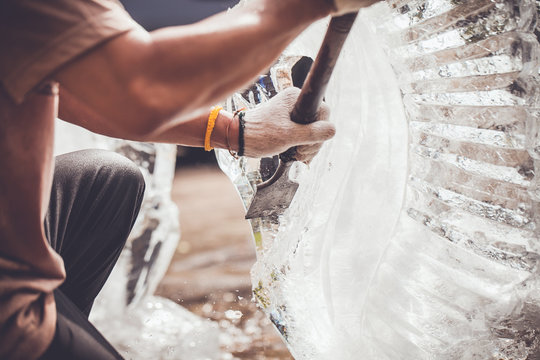 man is carving the ice sculpture for wedding