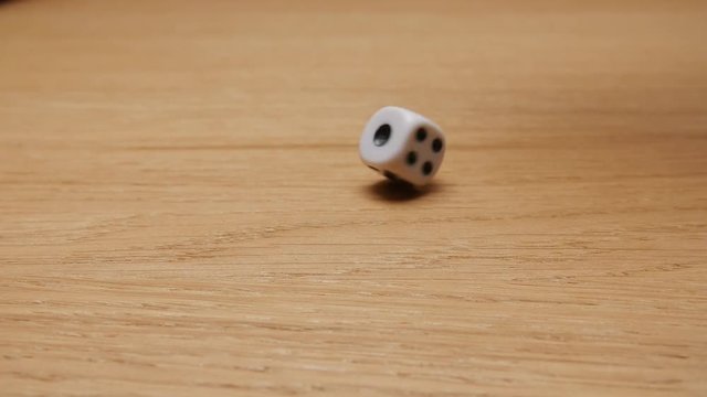 Dice rolling on the brown table. Slow motion. Close-up.