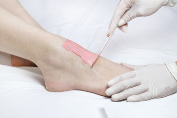 Process depilation female legs and hands in a beauty salon 