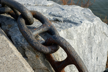 Ship anchor chain segment on a grey stone