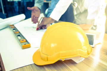 engineer helmet and anather object on table, engineer meeting concept, vintage tone.