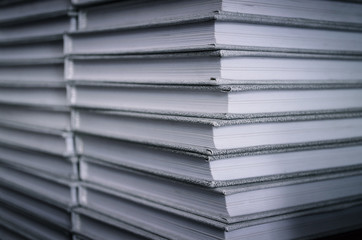 Stack of gray books on a bookshelf in the library. Front view. Education concept.