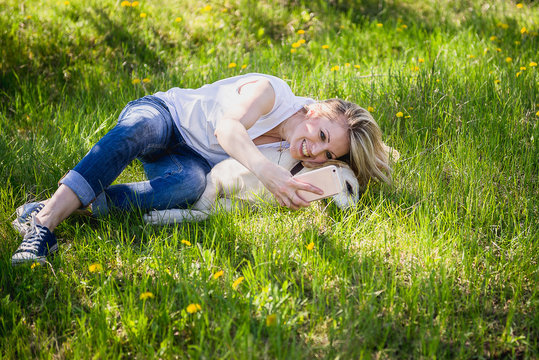 The girl makes selfie with a labrador
