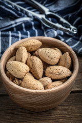 Almonds in-shell in wooden bowl.