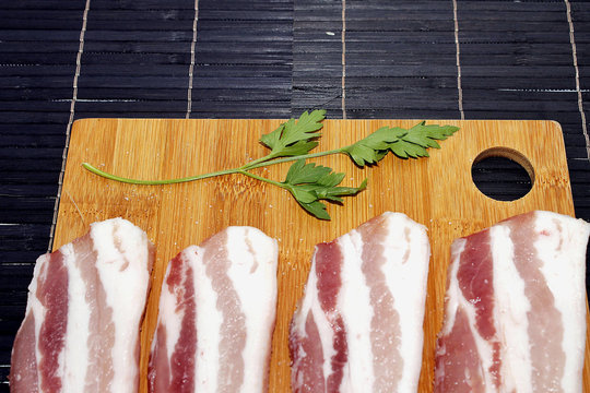 Baicon crudo encima de una tabla de madera.