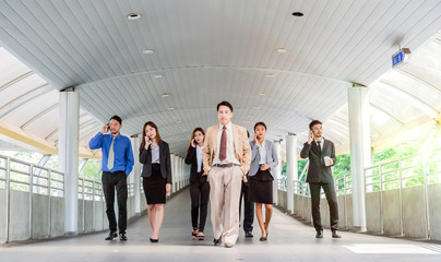Happy Asian Business people walking forward, modern city background, Business Teamwork concept.