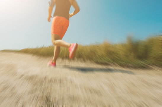 Abstract motion blur:  Young woman jogging cross-country running in summer seaside.  Concept fitness and healthy lifestyle