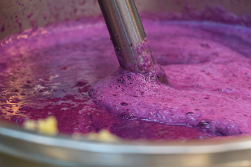Making smoothie from berries, milk, ghee butter - concept of bulletproof  and vegetarian diet. Closeup. Selective focus.
