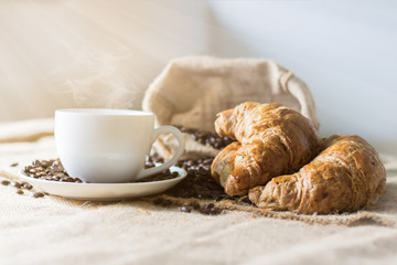 Coffee and Croissant are placed on the table in the morning.