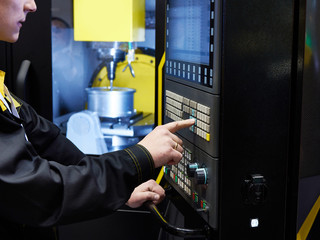 Worker controls CNC machine