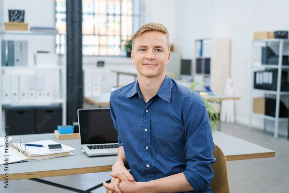 Wall mural junger geschäftsmann am schreibtisch im büro