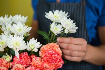 Fleuriste tenant des fleurs dans une boutique de fleuriste