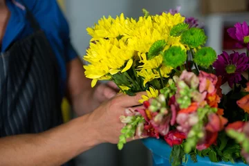 Photo sur Plexiglas Fleuriste Fleuriste tenant un bouquet de fleurs dans une boutique de fleuriste