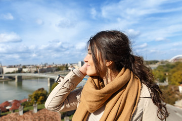 Portrait of young woman with town panorama in background.