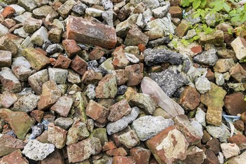 Pile of broken red bricks with garbage. Stock image.
