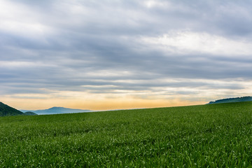 Landschaftspanorama mit aussicht auf die Berge und wollen am Himmel bei Sonnenaufgang