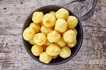 Bowl of potato balls on wood, from above