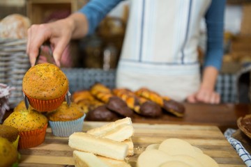 Mid-section of staff working at bakery counter