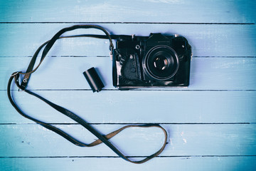 Retro film camera on a blue wooden surface