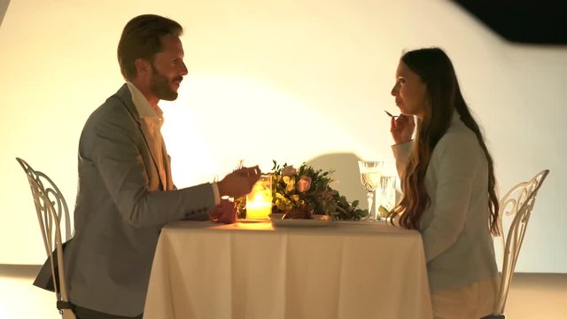 4k video, beautiful dressed young honeymoon couple enjoying private dinner on cool summer evening on terrace of luxury restaurant in greece
