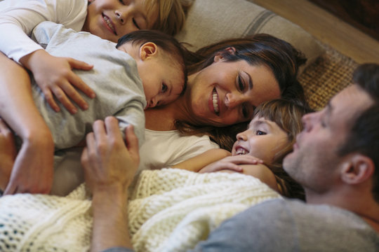 High Angle View Of Kids With Parents Sleeping On Carpet At Home