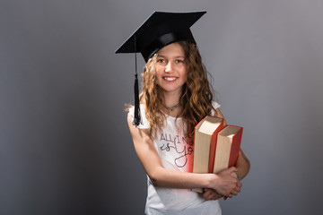Young college graduate girl holding books