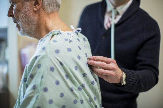 Midsection of male doctor listening to patient's breathing in hospital ward