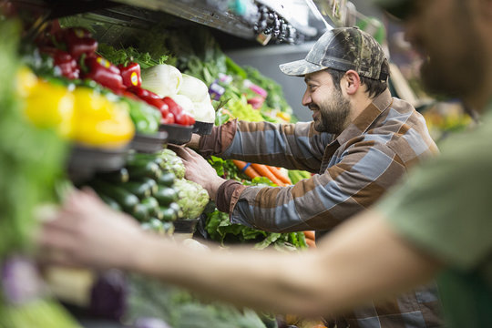 Workers arranging vegetables at supermarket