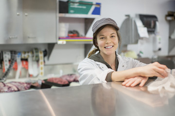 Portrait of happy female worker standing by display cabinet