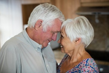 Happy senior couple looking at each other in kitchen