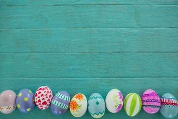 Painted Easter eggs on wooden surface - obrazy, fototapety, plakaty