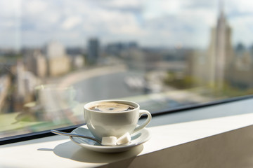 coffee Cup on windowsill with city view